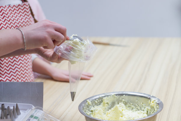 厨师在糕点袋里装满奶油，用来做泡芙蛋糕图片下载