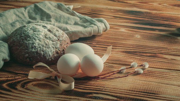 复活节明信片，白色的鸡蛋，发芽的柳树和黑麦面包在深色的米色木制背景上图片下载