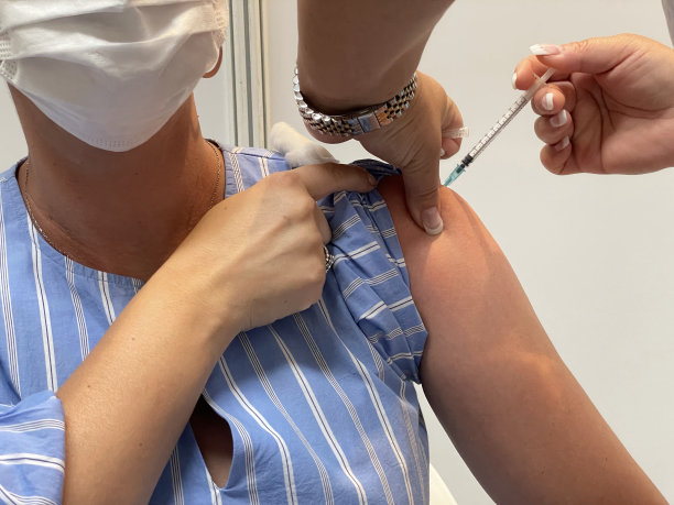 在接种期间，一名女护士正在向一名男病人的左臂注射疫苗。一个近距离和选择性聚焦照片的针和针。一张医学概念照片。图片下载