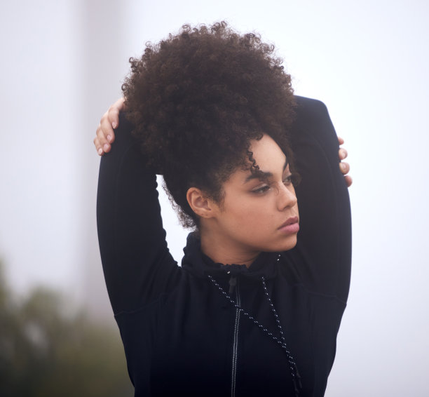 一个有魅力的年轻女运动员在一个雾蒙蒙的早晨站在外面的剪裁照片图片下载