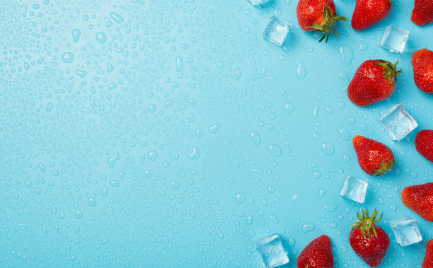 上面的照片是一堆草莓，冰块和水滴孤立的蓝色背景与空白图片下载