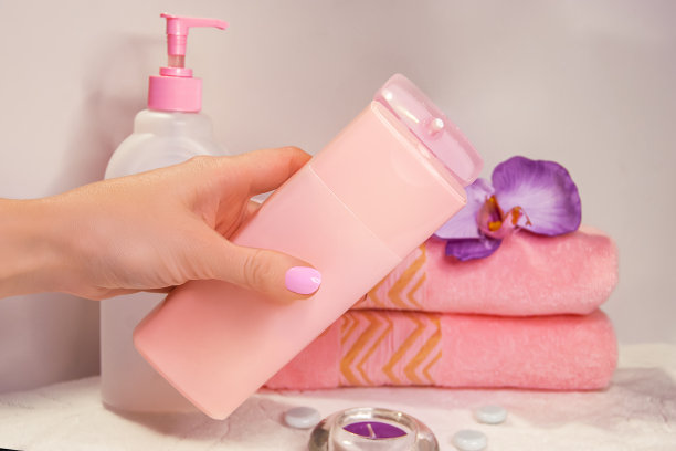 一个女人的手正要从瓶子里挤出润肤露。完美美甲的照片。Spa静物。图片下载