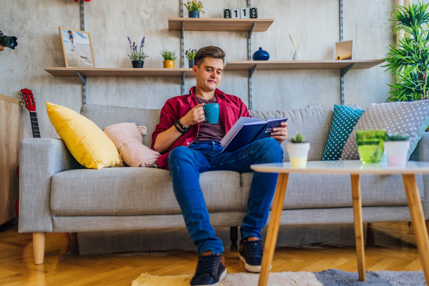 男人端着一杯咖啡，在读一本书图片下载