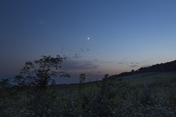 日落后美丽夜空的彩色照片。年轻亮月和金星。山里的寂静。山林中有树木和植物的自然景观。图片下载