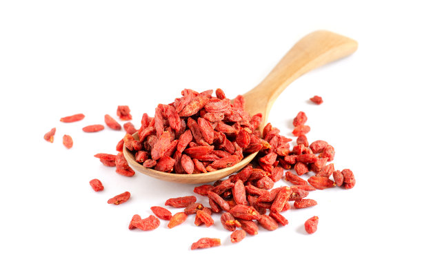 封闭干枸杞果堆在木勺上白色背景准备食物原料或调味料图片下载