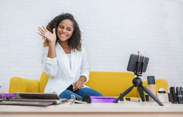 年轻黑人女性肖像评论赠品给粉丝跟踪频道，同时录制视频与化妆化妆品在家里。网红女孩在社交媒体上直播蒸概念图片下载