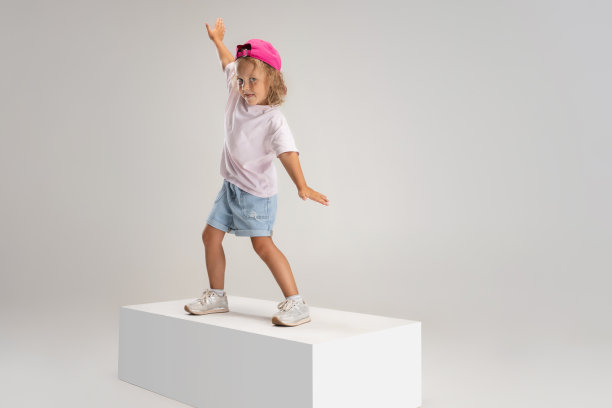 嘻哈跳舞。小学前班白种人女孩的肖像，穿着便服孤立在白色工作室背景。图片下载