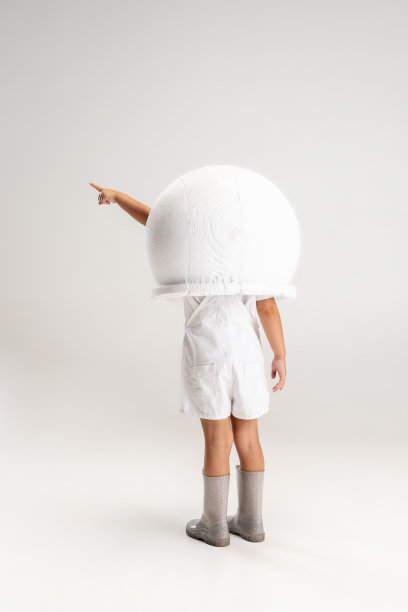 后视图的小学前班的女孩在大头盔摆姿势孤立在白色的工作室背景。图片下载