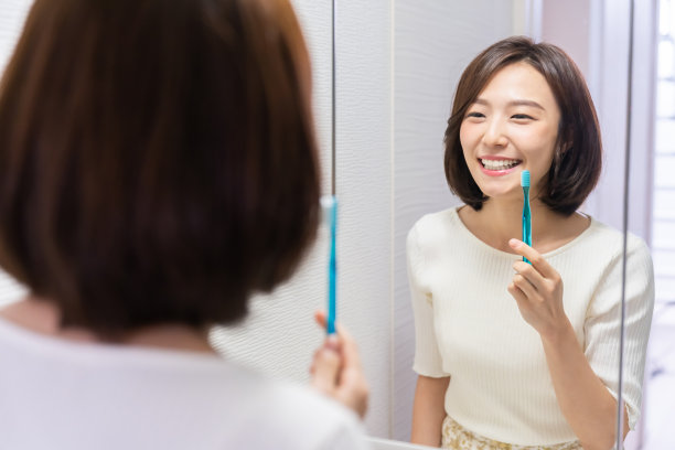 漂亮的亚洲女人，有健康的牙齿，拿着牙刷图片下载