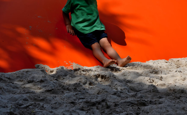 孩子们在塑料充气油布上玩耍。这是一个不断膨胀的泡沫。压缩机给它充气，它周围有硅砂。孩子们玩球玩得很开心图片下载