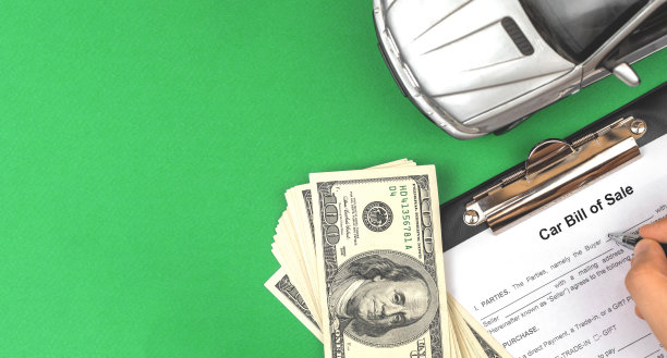 购买新车，填写和签署文件和表格。卖单协议。绿色办公桌面，钞票和玩具车，俯视图照片图片下载