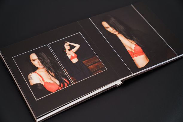 打开一本照片簿，从一个有魅力的女人在一个黑色背景的照片拍摄。图片下载