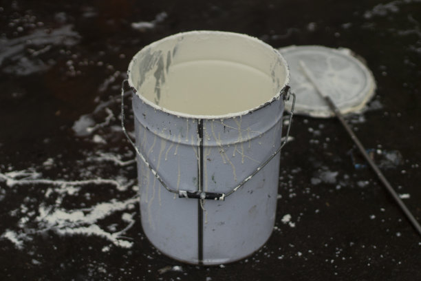 白色的油漆桶。桶在沥青上。图片下载