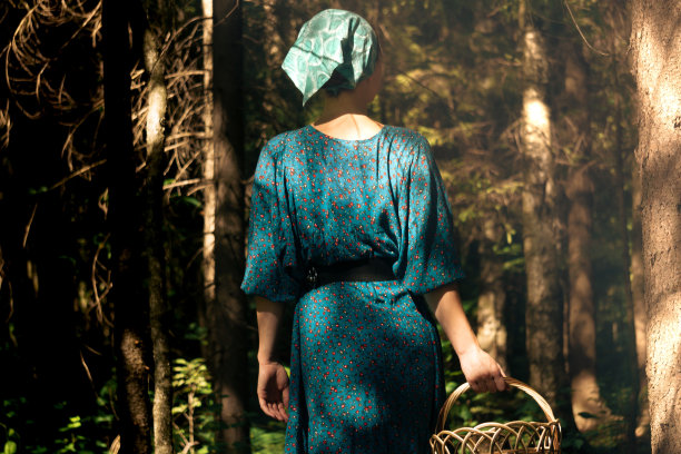 针叶林里的年轻女子，穿着农民的衣服，提着篮子图片下载