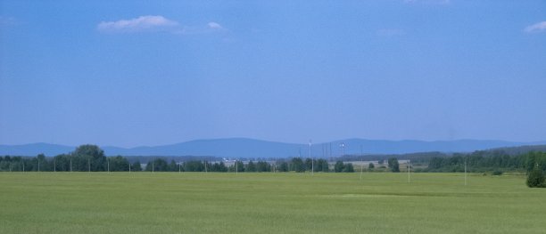 远处是长满青草的平原和群山图片下载