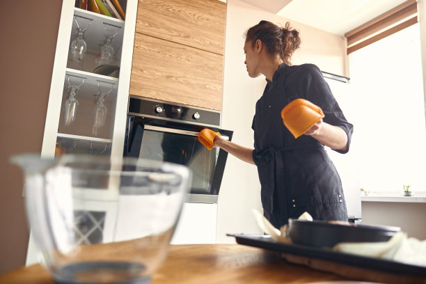 年轻的职业女厨师正在她的轻现代厨房里准备美味的蛋糕图片下载