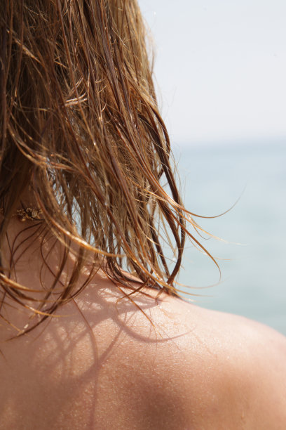 沙滩上女人的头发。湿头发近距离图像。海水和阳光对头发的伤害，夏日护发理念。图片下载