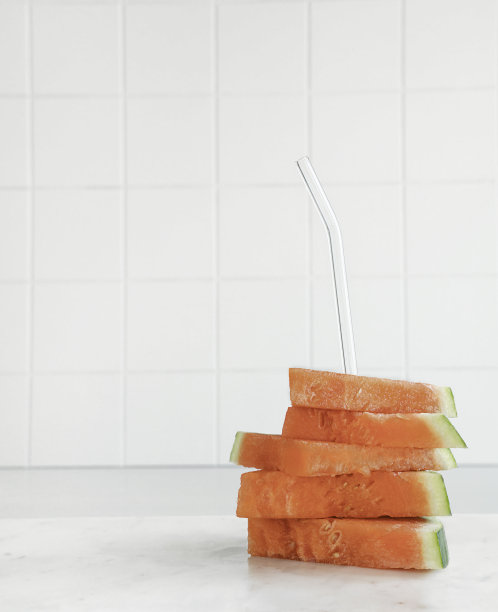 堆叠新鲜的西瓜片与玻璃饮水吸管在白色背景库存照片图片下载