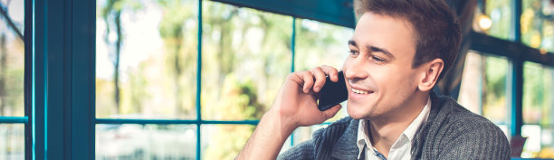 拿着一杯咖啡的快乐男人在餐厅里打电话图片下载