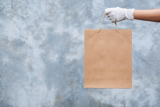 戴着医用橡胶手套的手，为顾客手持和运送购物袋，医疗保健和Covid-19概念图片下载