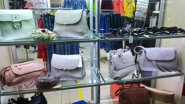 时尚女性手提包在柔和的颜色在商店橱窗。服装和配件时尚精品。玻璃展示。新的集合。买衣服。纺织和服装工业。购物中心图片下载