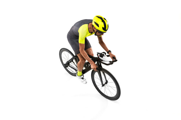 从以上观点。一个年轻的职业自行车运动员在运动服，男子骑公路自行车孤立的白色背景。图片下载