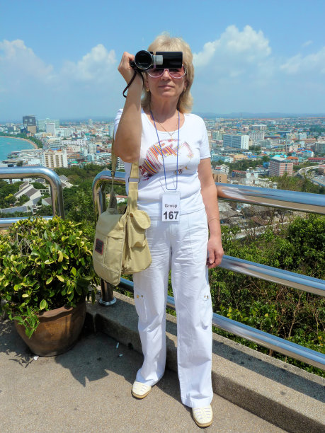 一名女子在观景台上用相机拍照图片下载