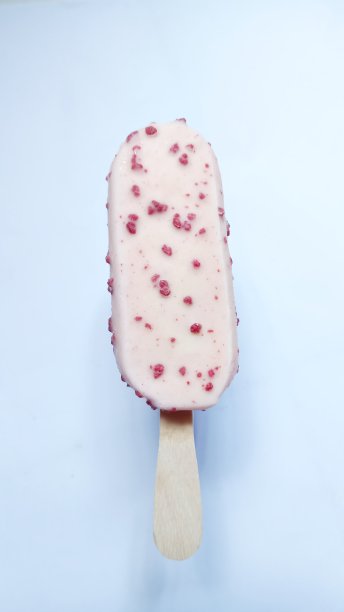 一根缀有巧克力屑的粉色冰淇淋棒图片下载