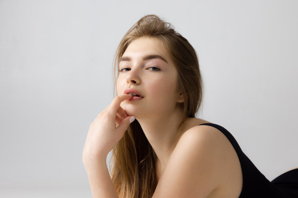 特写美丽可爱的年轻女孩在黑色内衣摆孤立在灰色的工作室背景。自然美容、spa美容、化妆品美容概念。图片下载