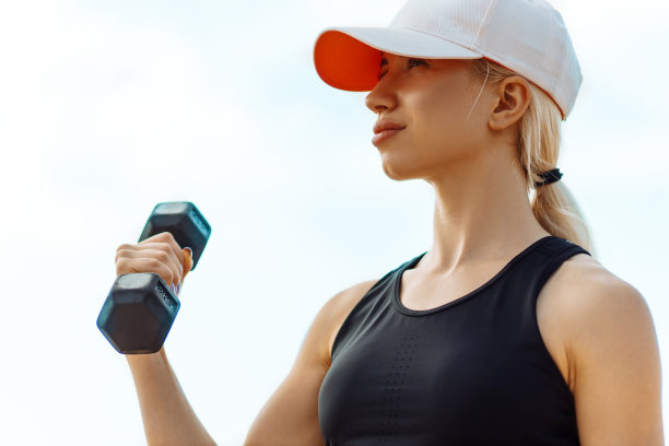 健康的年轻健身女人，在运动服，做练习与哑铃在海滩上，运动美丽的年轻女人与哑铃户外图片下载