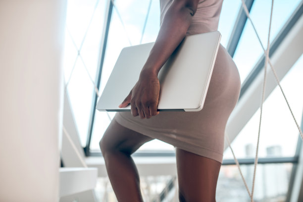 女人带着笔记本电脑自信地爬楼梯图片下载