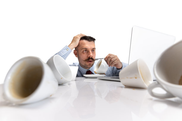 年轻打瞌睡的白人男子的肖像，办公室工作人员坐在桌子上的白色背景。图片下载