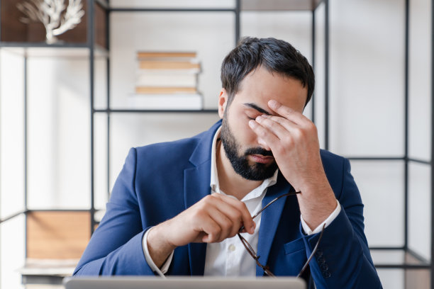 过度用眼导致视力负担过重，因工作狂、使用笔记本电脑导致的眼睛问题和视力下降，疲惫、压力大的商人出现疲劳、抑郁、工作问题、头痛和偏头痛图片下载