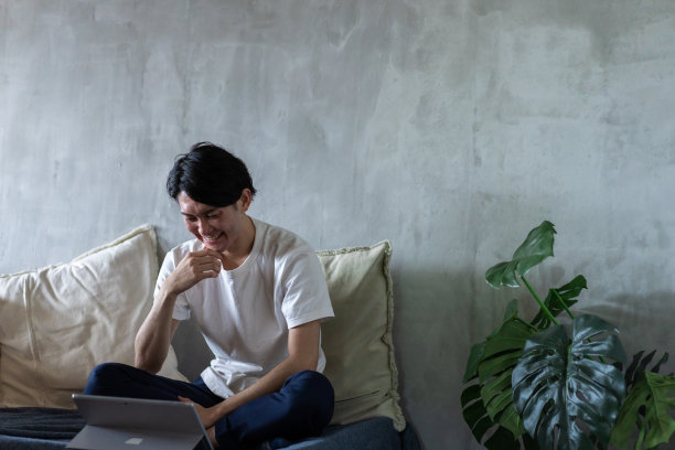 年轻人在家躺在床上工作图片下载