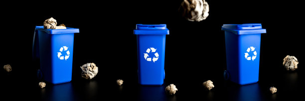 垃圾分类收集。垃圾箱容器用于处理垃圾废物，节约环境。蓝色垃圾桶用于回收塑料，纸张和玻璃罐垃圾隔离在黑色背景上。图片下载
