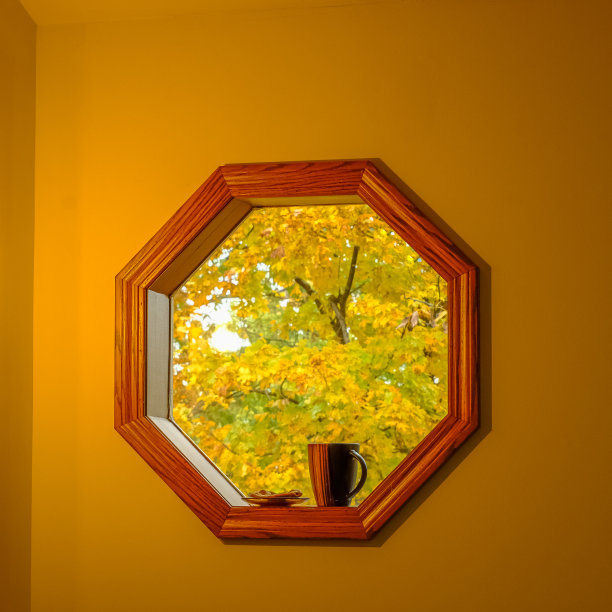 下雨天透过八角形窗观赏室内秋叶图片下载