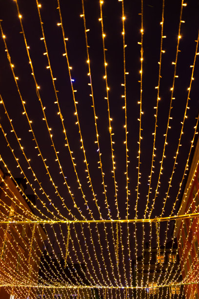 华沙，波兰老城区的大街上，金灿灿的圣诞节日灯饰挂在夜空中仰望图片下载