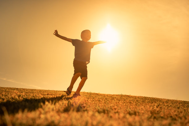 日落时分快乐的小男孩。图片下载