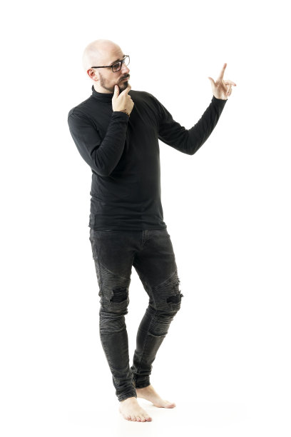 光秃秃、光着脚、穿着黑色衣服的另类风格男人一边思考一边指指点点图片下载