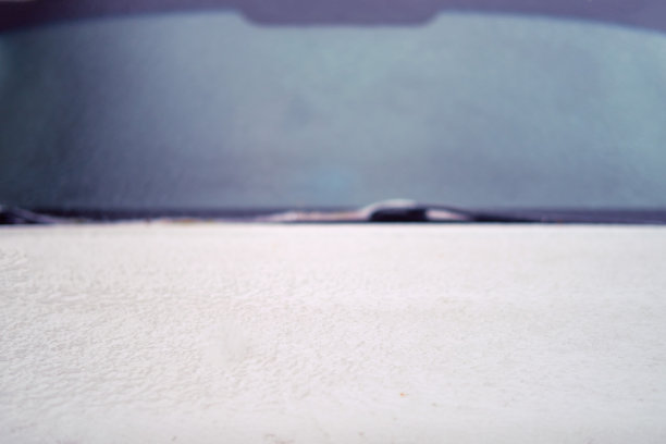 一辆汽车的挡风玻璃和引擎盖在秋天的第一场霜冻后冻结了图片下载