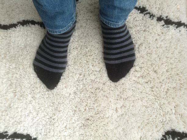 地毯上穿袜子的男人，俯视图图片下载