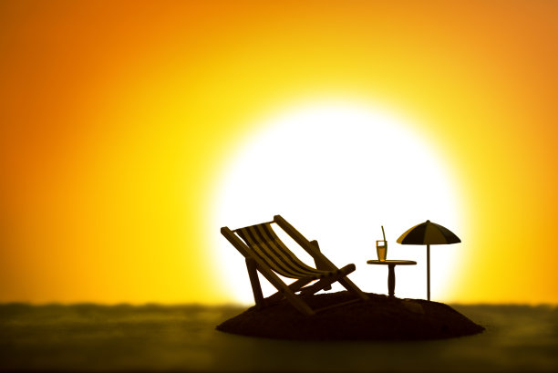 一张小岛的静物照片，上面有一把伞，一张日光浴床，一张桌子和一杯饮料。图片下载