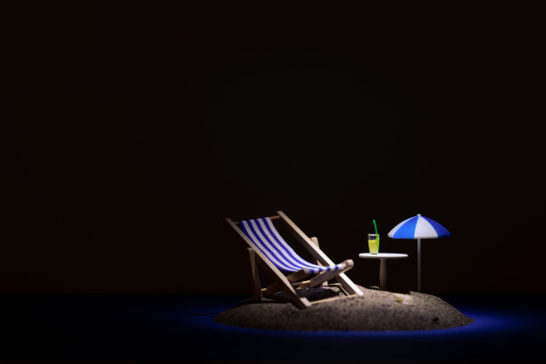 一张小岛的静物照片，上面有一把伞，一张日光浴床，一张桌子和一杯饮料。图片下载