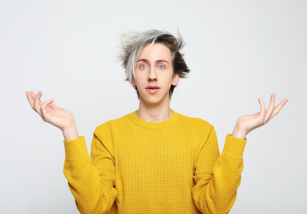 英俊的男子穿着黄色毛衣，一脸惊讶和惊讶的表情图片下载