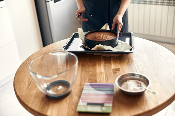 年轻的职业女厨师正在她的轻现代厨房里准备美味的蛋糕图片下载