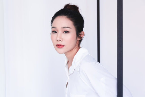 亚洲女性干净清新的皮肤摆出时尚的造型。一个微笑的黑发女人的肖像自然的化妆微笑后，奇妙的脸处理。护肤美容理念。图片下载