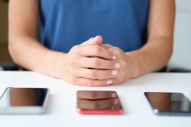 三个现代触屏智能手机躺在桌子上的女人抱着胳膊图片下载