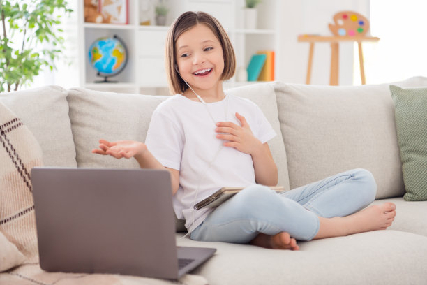 照片的闪亮印象小女孩穿着白色t恤坐在教练视频呼叫现代小工具室内房间家的房子图片下载