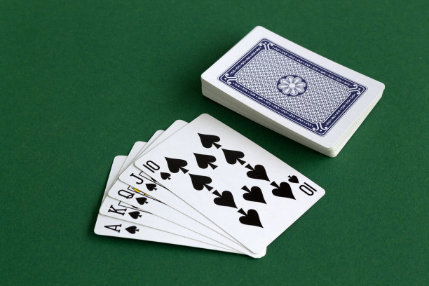 皇家同花黑桃。在绿色的桌子上用蓝色的桥牌打牌。组合的卡在一个绿色的赌场桌面背景。扑克。图片下载