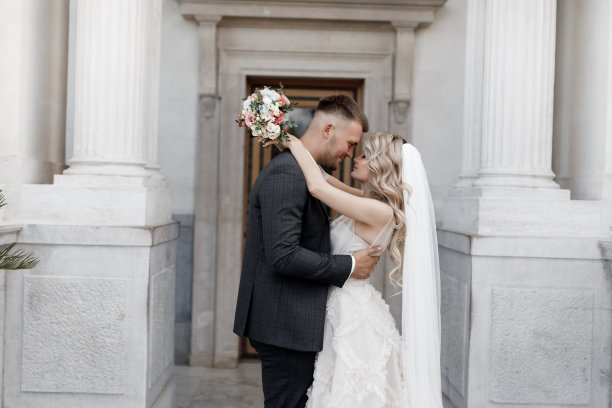 新娘身穿白色婚纱，新郎身穿深色西装，背景是婚礼宫殿图片下载